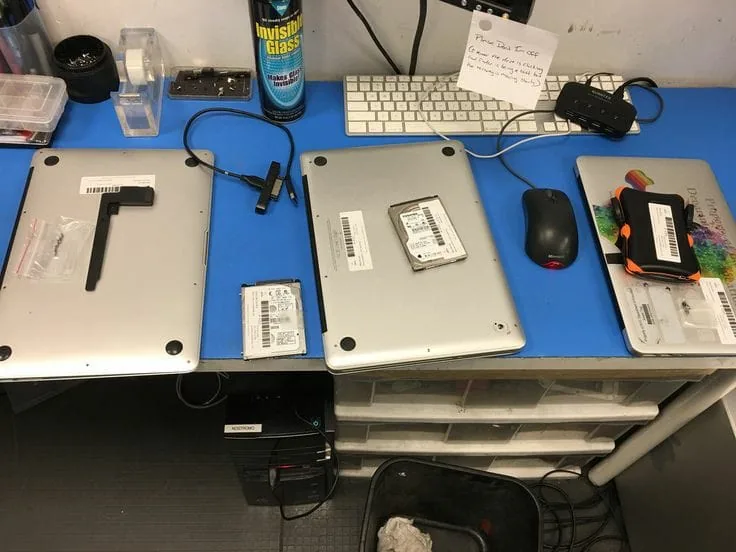Laptops open on the bench during SSD and hard drive upgrades